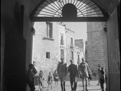 ...l�opera del neozelandese ci restituisce anche uno spaccato della citt� vecchia.Abbiamo ritratti di soldati nei passeggiano all�ingresso del Palazzo Arcivescovile, osservati dai bambini del centro storico con un misto di curiosit� e ammirazione

(F. Alexander Turnbull Library, Welligton, NZ. Ref. DA-04519-F)